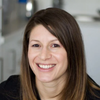 Anthea Mccourtie is a registered nutritional therapist, she supports the combination of adaptogens and nootropics within noops day and night supplements. Anthea  hasmedium-length brown hair is smiling warmly while looking directly at the camera. She is wearing a dark-colored top, and the background features a softly blurred indoor setting